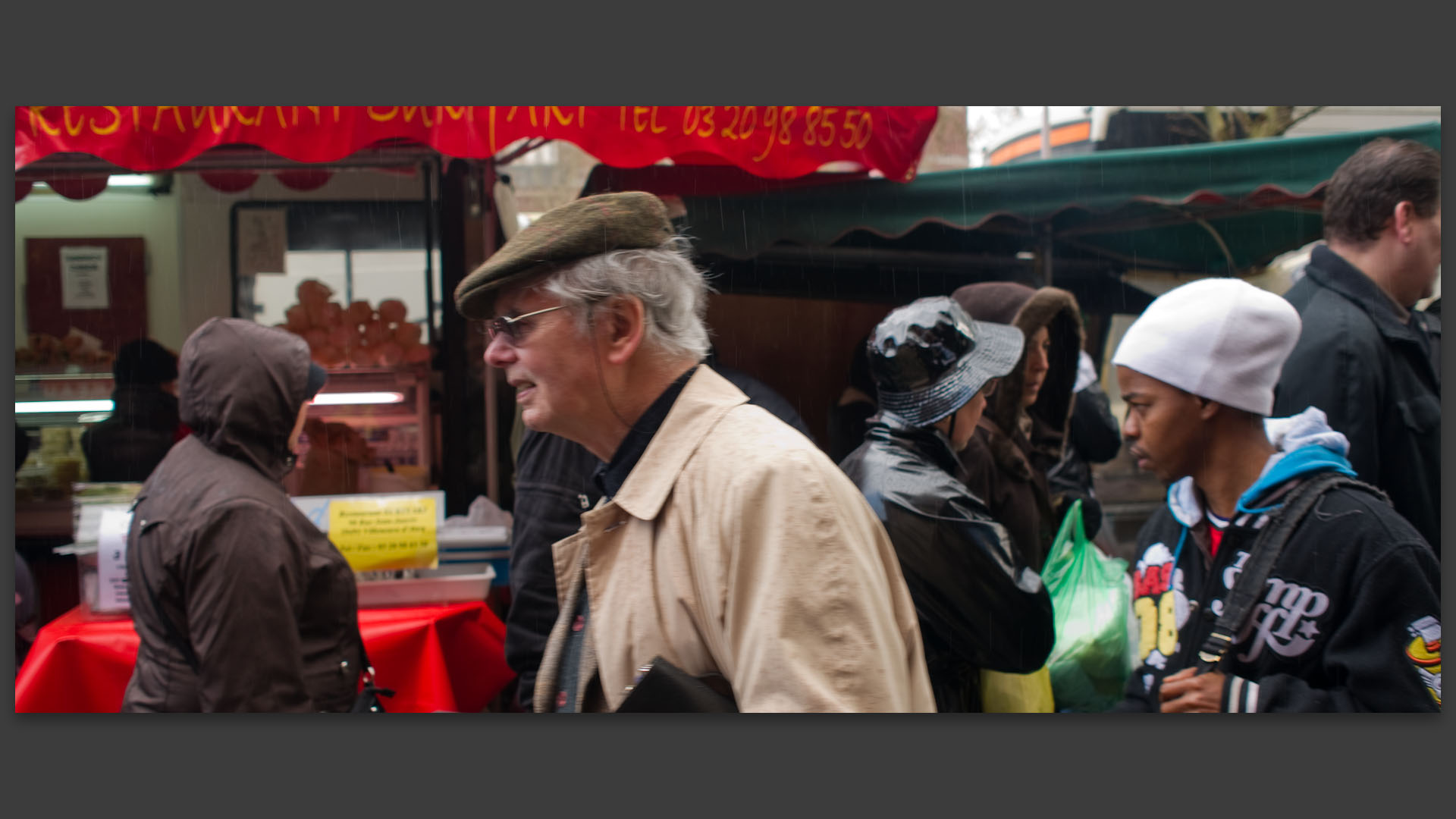 Vieil homme sous la pluie, au marché de Wazemmes, place de la Nouvelle Aventure, à Lille.