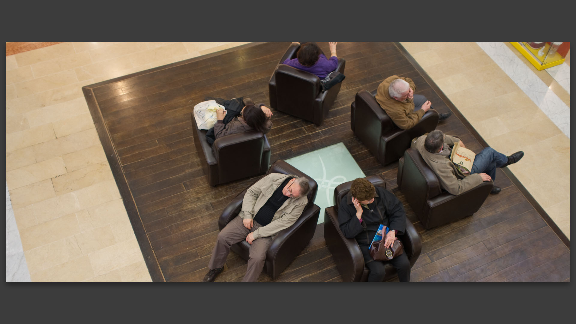 Homme dormant dans un fauteuil, au centre commercial des Tanneurs, à Lille.