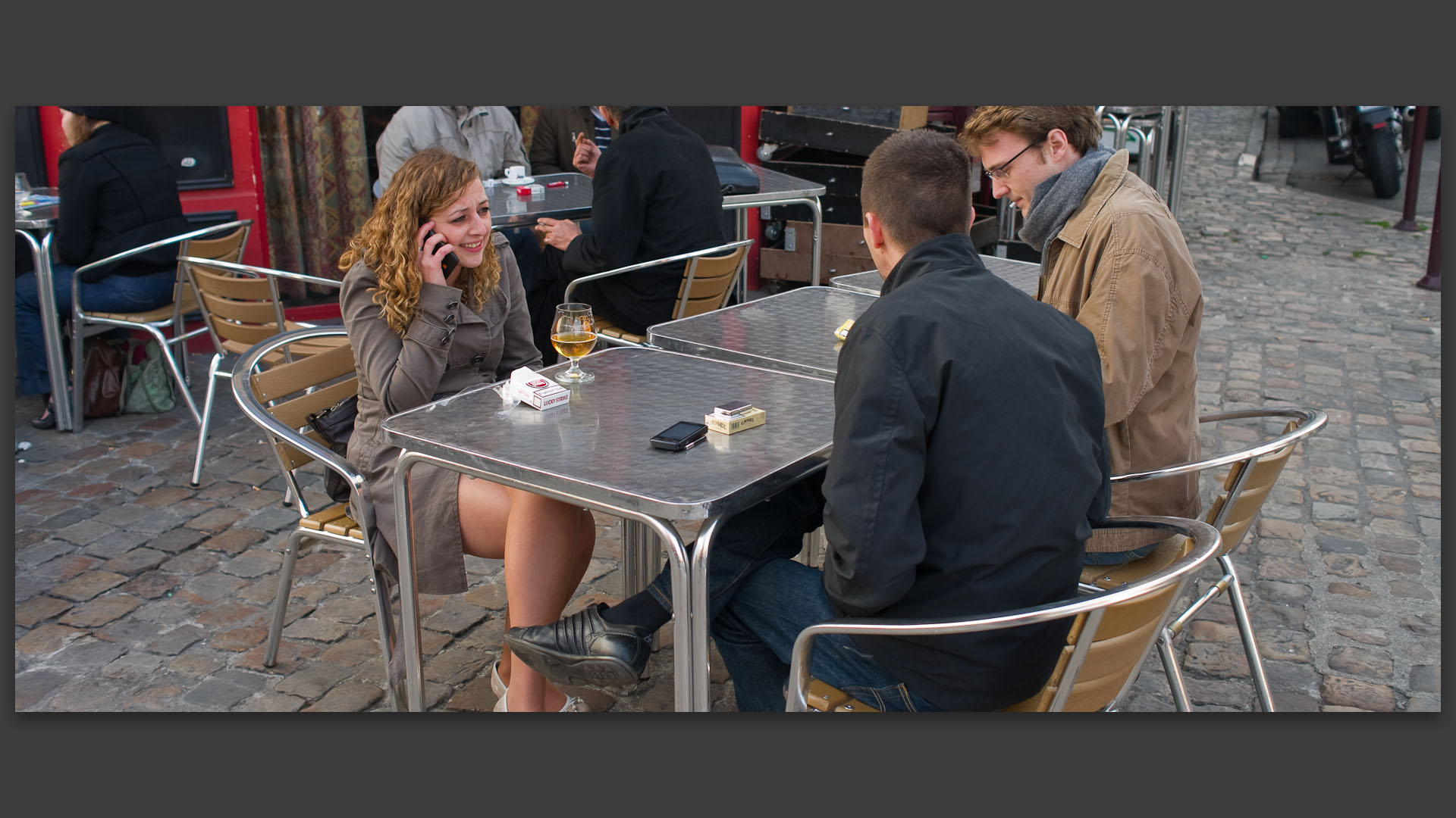 Jeune femme au téléphone portable, à la terrasse de l'Oxford, parvis de Croix, à Wazemmes, Lille.