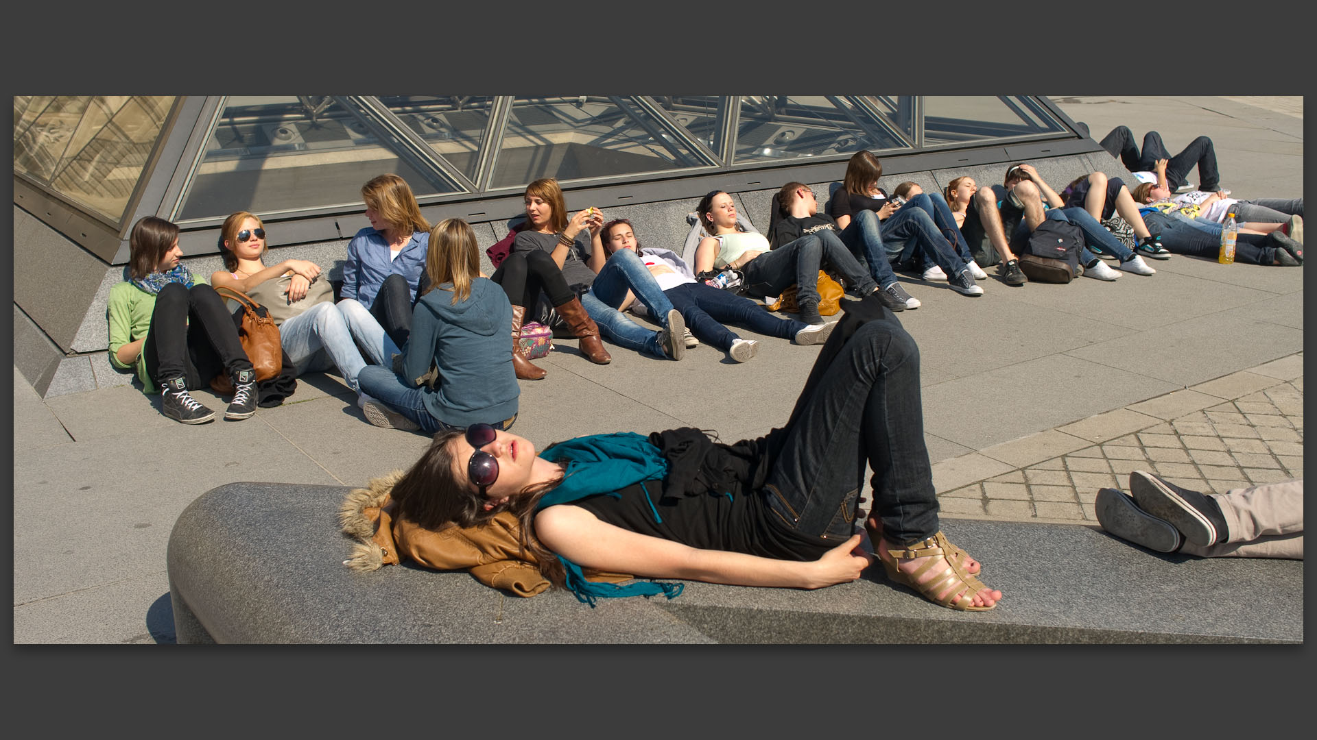 Sieste collective, à la pyramide du Louvre, à Paris.