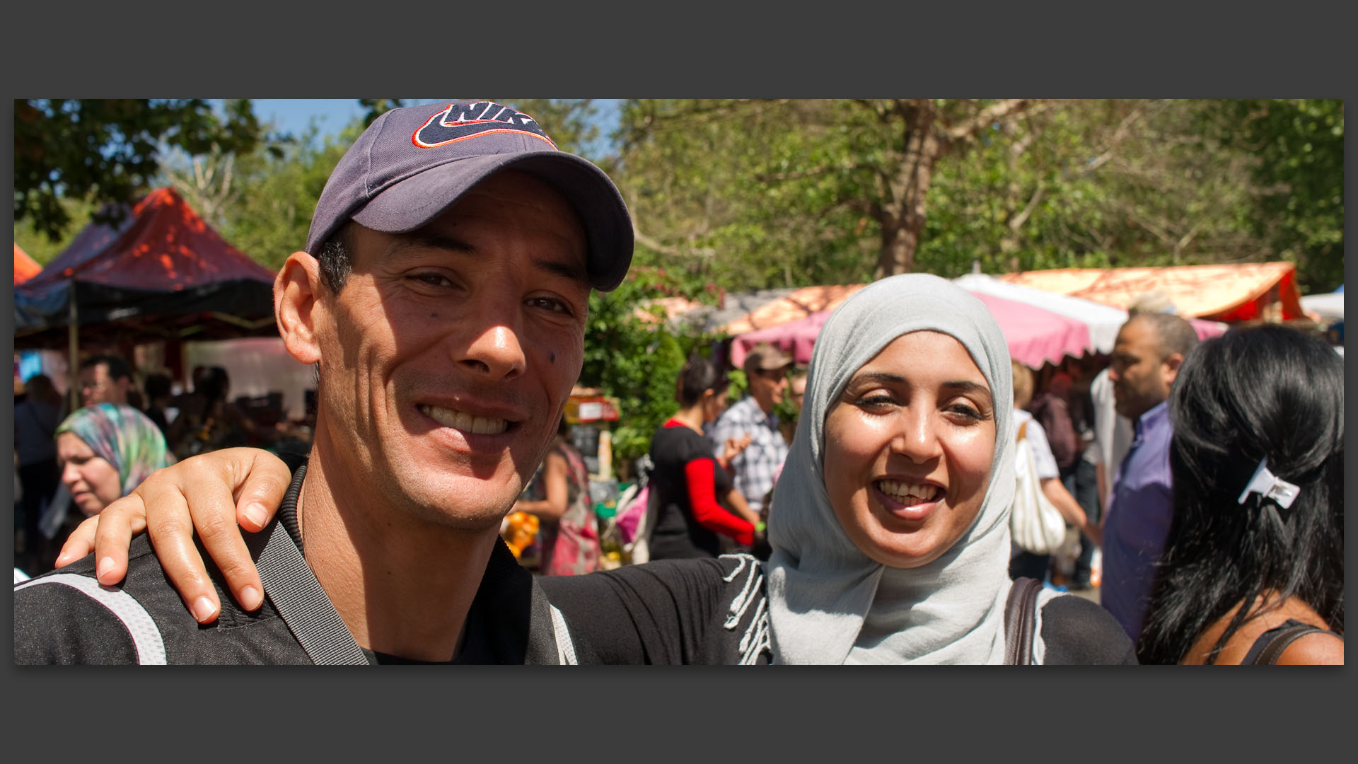 Jeune couple, lui avec une casquette, elle avec le voile, au maché de Wazemmes, place de la Nouvelle Aventure, à Lille.