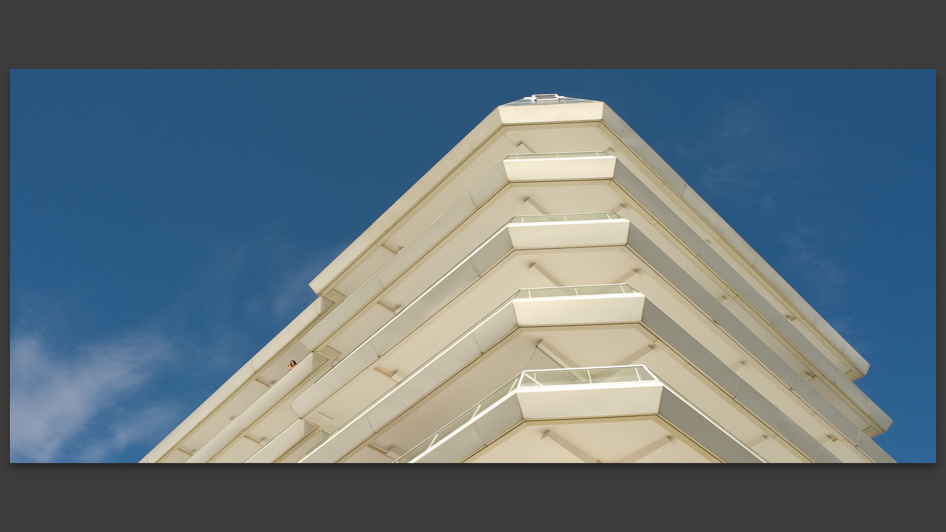 Femme fumant au balcon d'un immeuble moderne du front de mer, au Touquet Paris plage.