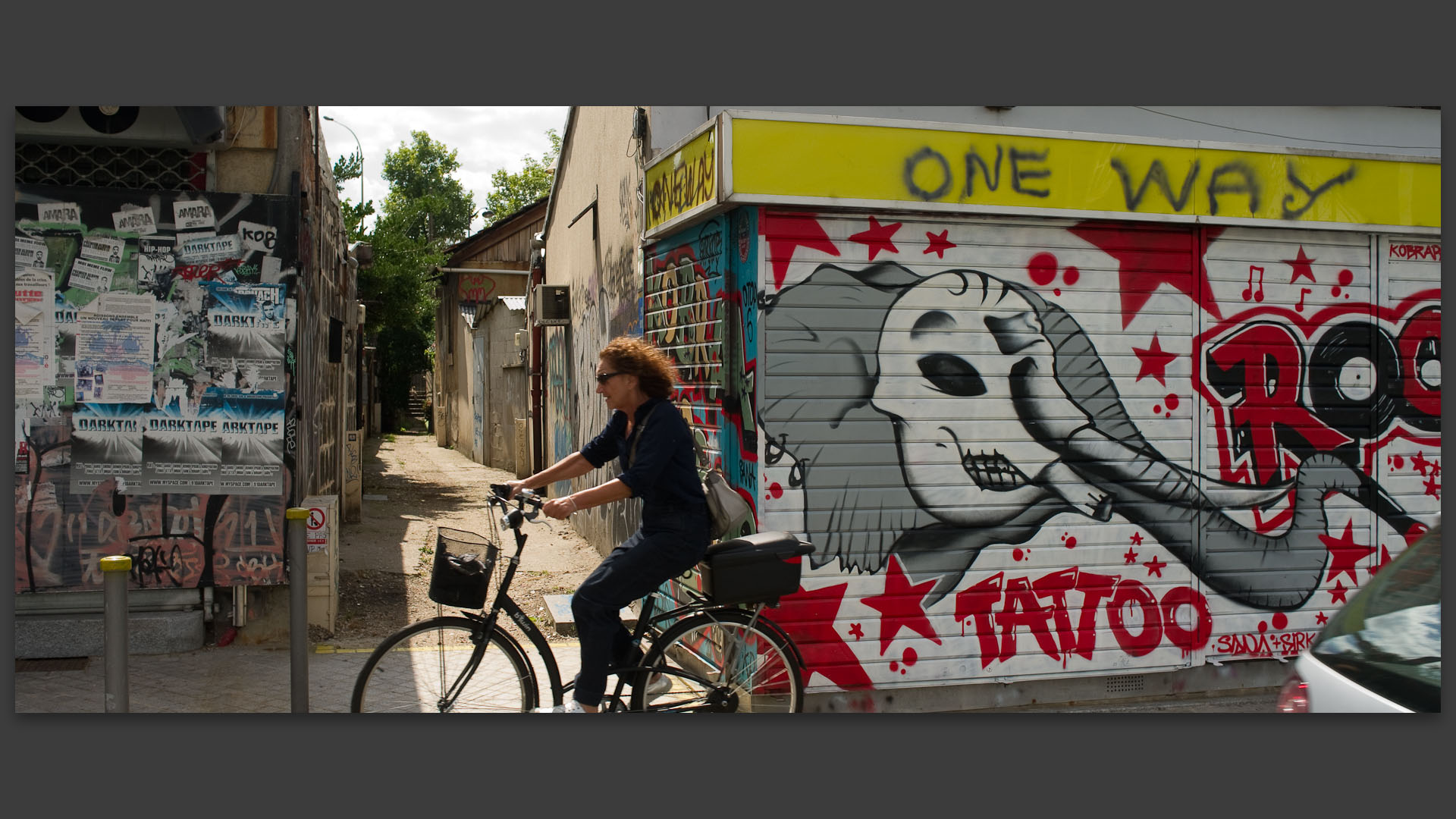 Cycliste, rue Jules-Vallès dans les Puces de Saint-Ouen.