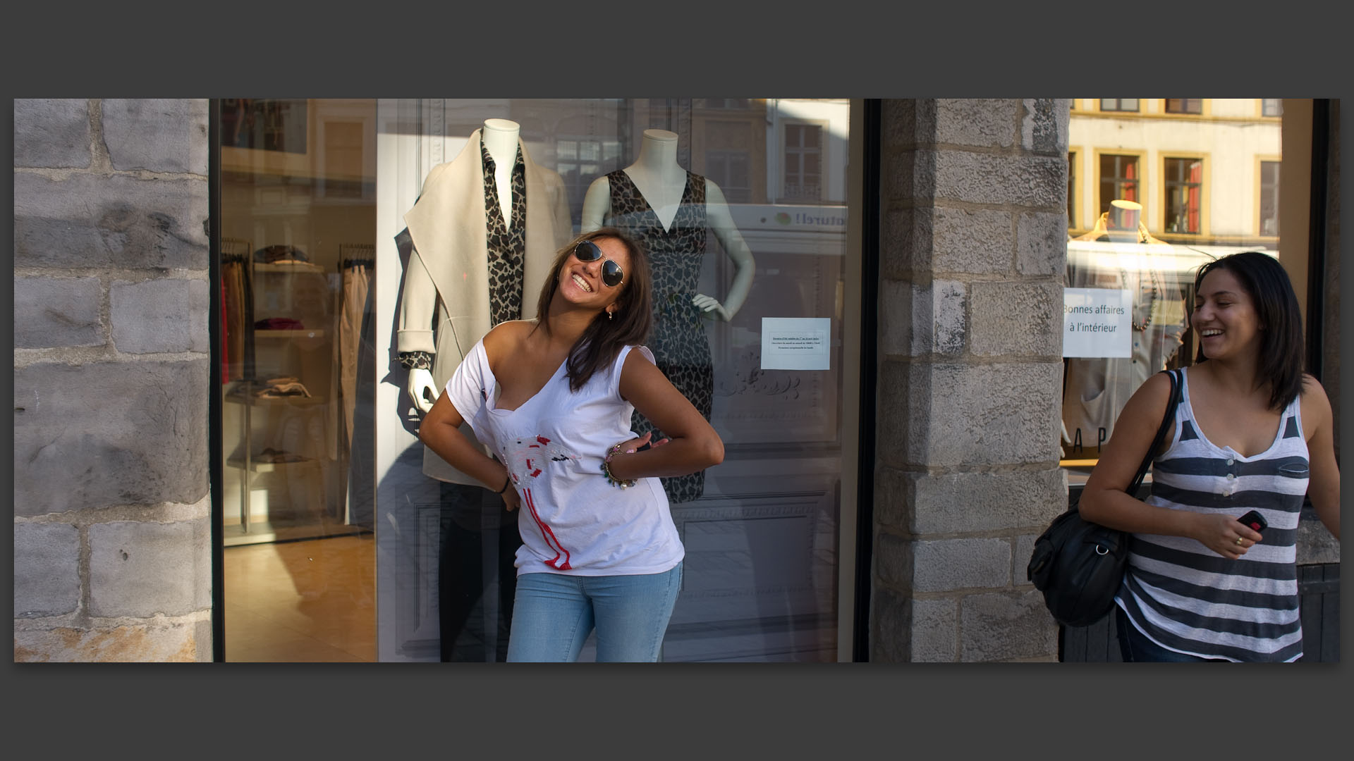 Jeune fille facétieuse devant une vitrine, rue de la Monnaie, à Lille.