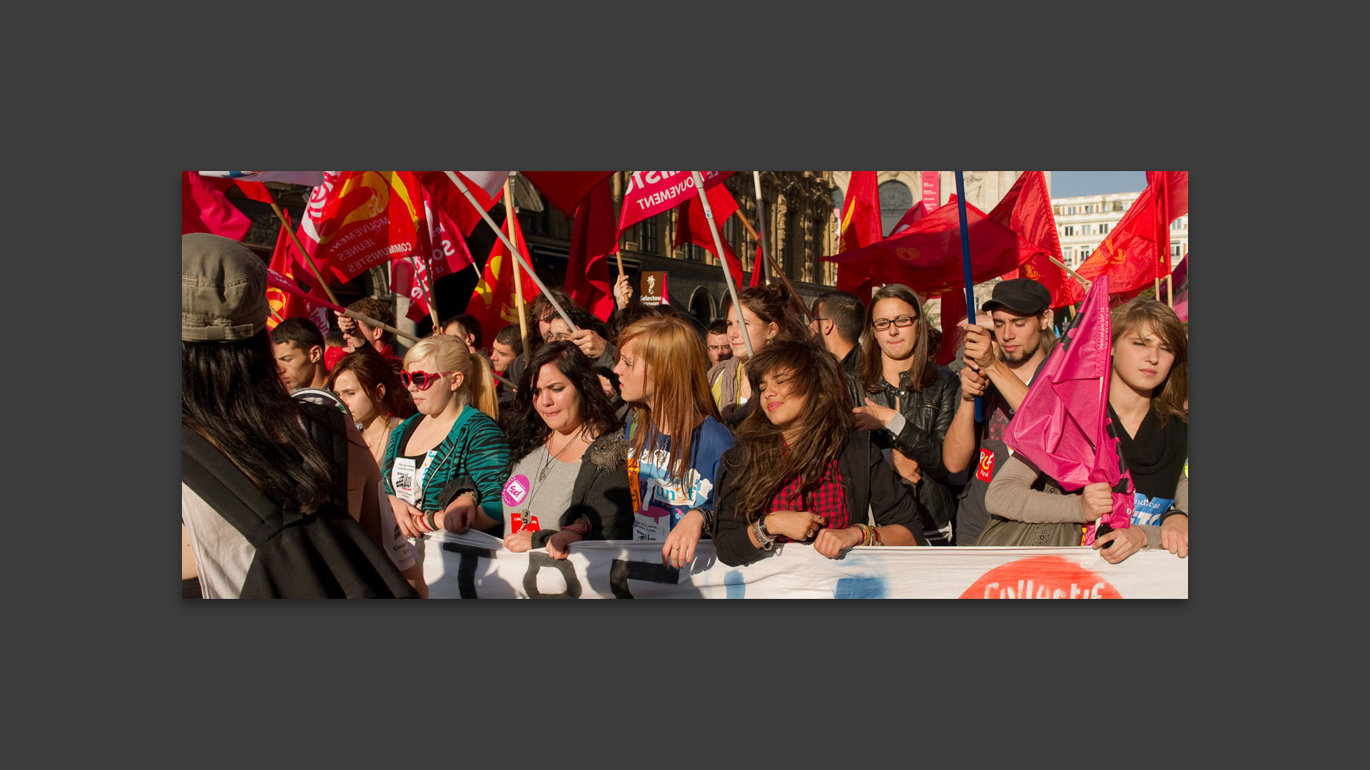 Jeunes étudiants tenant une banderole et des drapeaux dans le cortège de la manifestation contre la réforme des retraites.