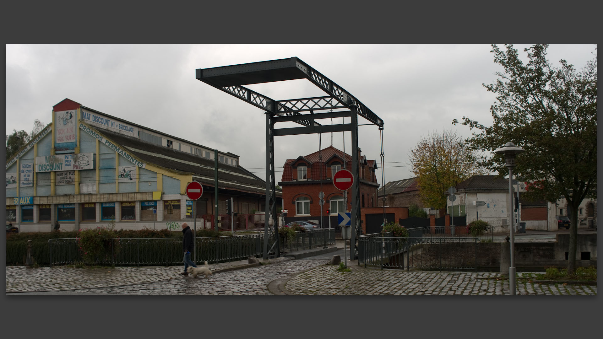 Passant avec son chien, quai du Havre, à Tourcoing.