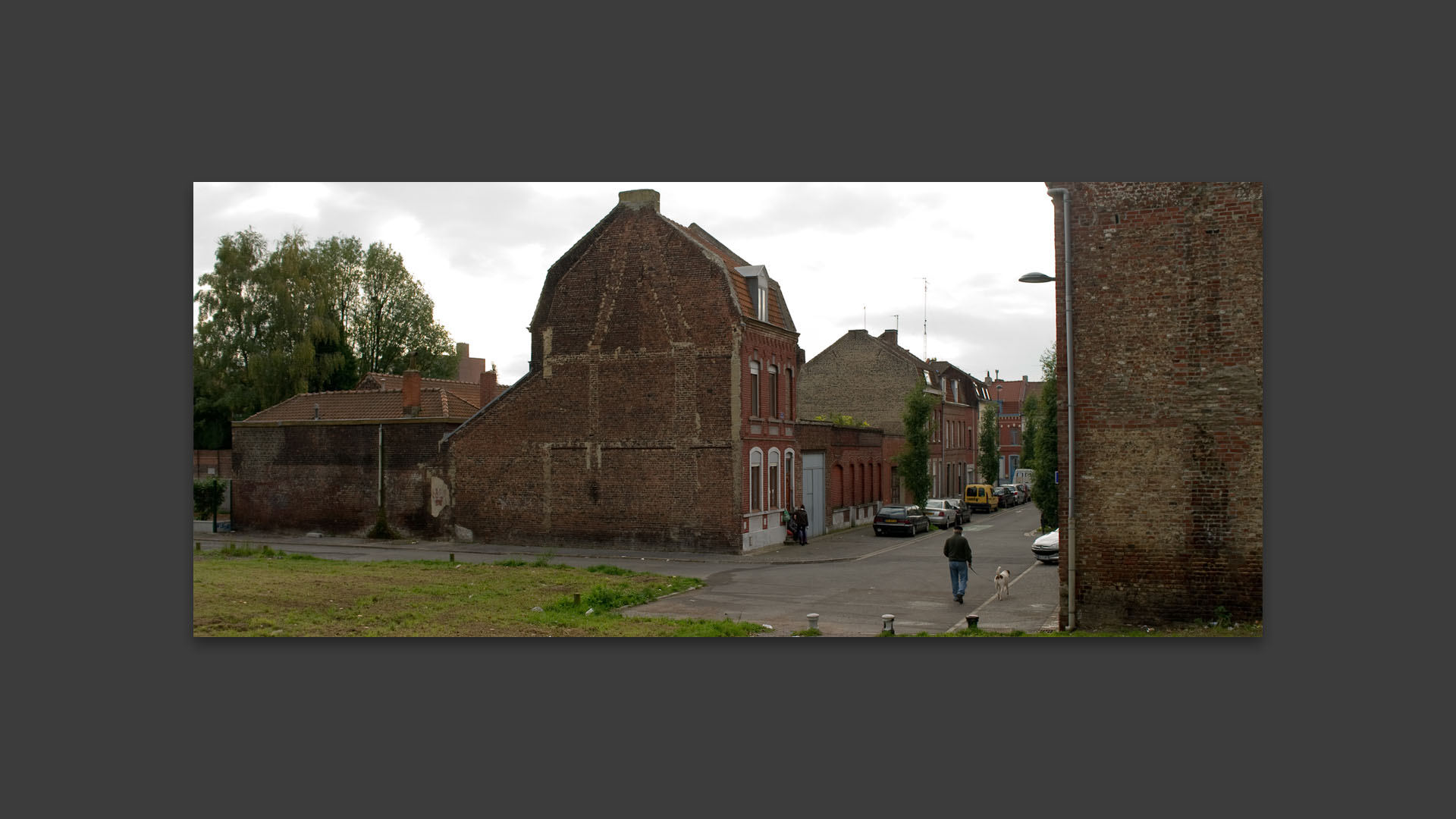 Passant avec son chien, rue Galilée, à Roubaix.