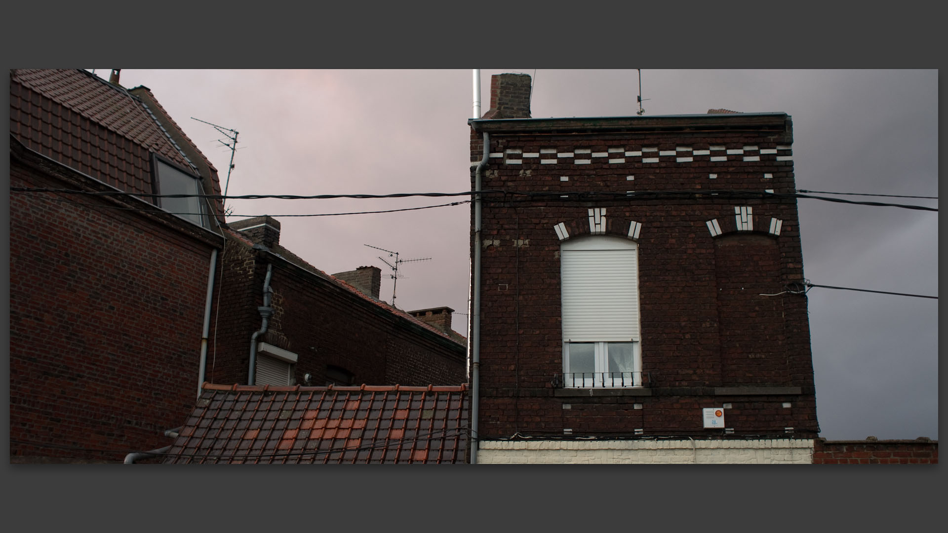 Ciel noir sur de vieilles maisons, rue Jean-Baptiste-Delescluse, à Croix.