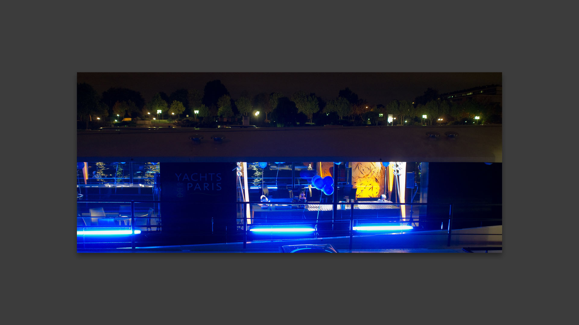 Illumination en bleu des yachts de Paris, quai Henri IV, à Paris.