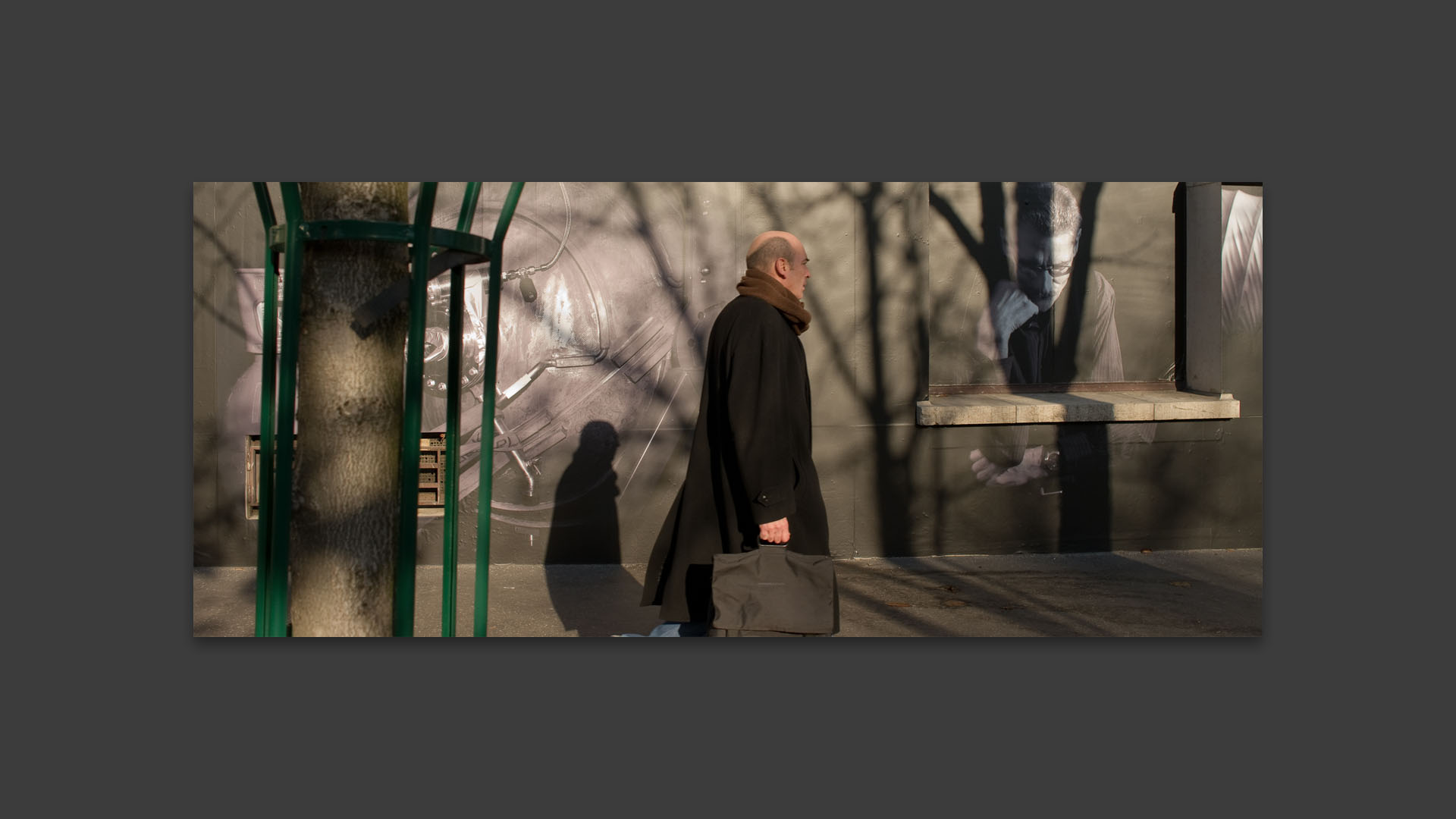 Homme marchant devant une fresque photographique de Grégoire Eloy sur le bâtiment de l'institut d'astrophysique, boulevard Arago, à Paris.