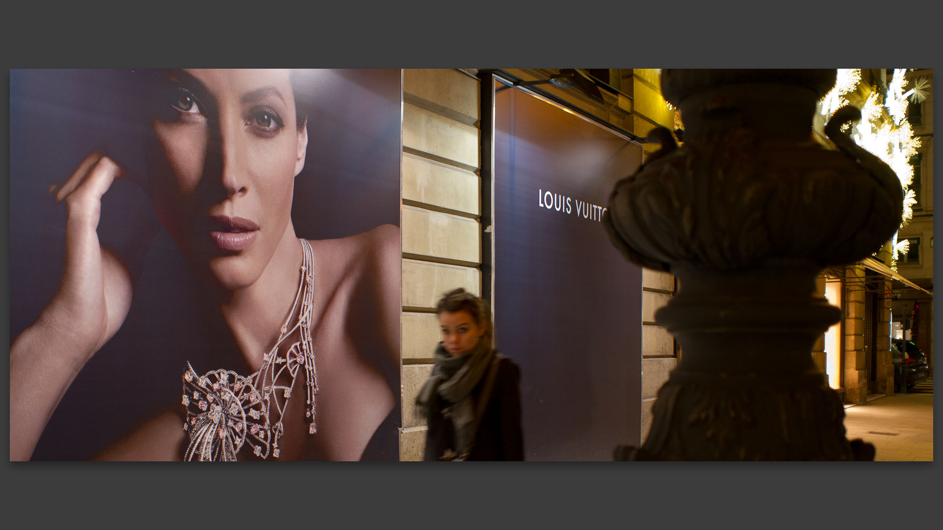 Devant une affiche Louis-Vuitton, rue de la Paix, à Paris.