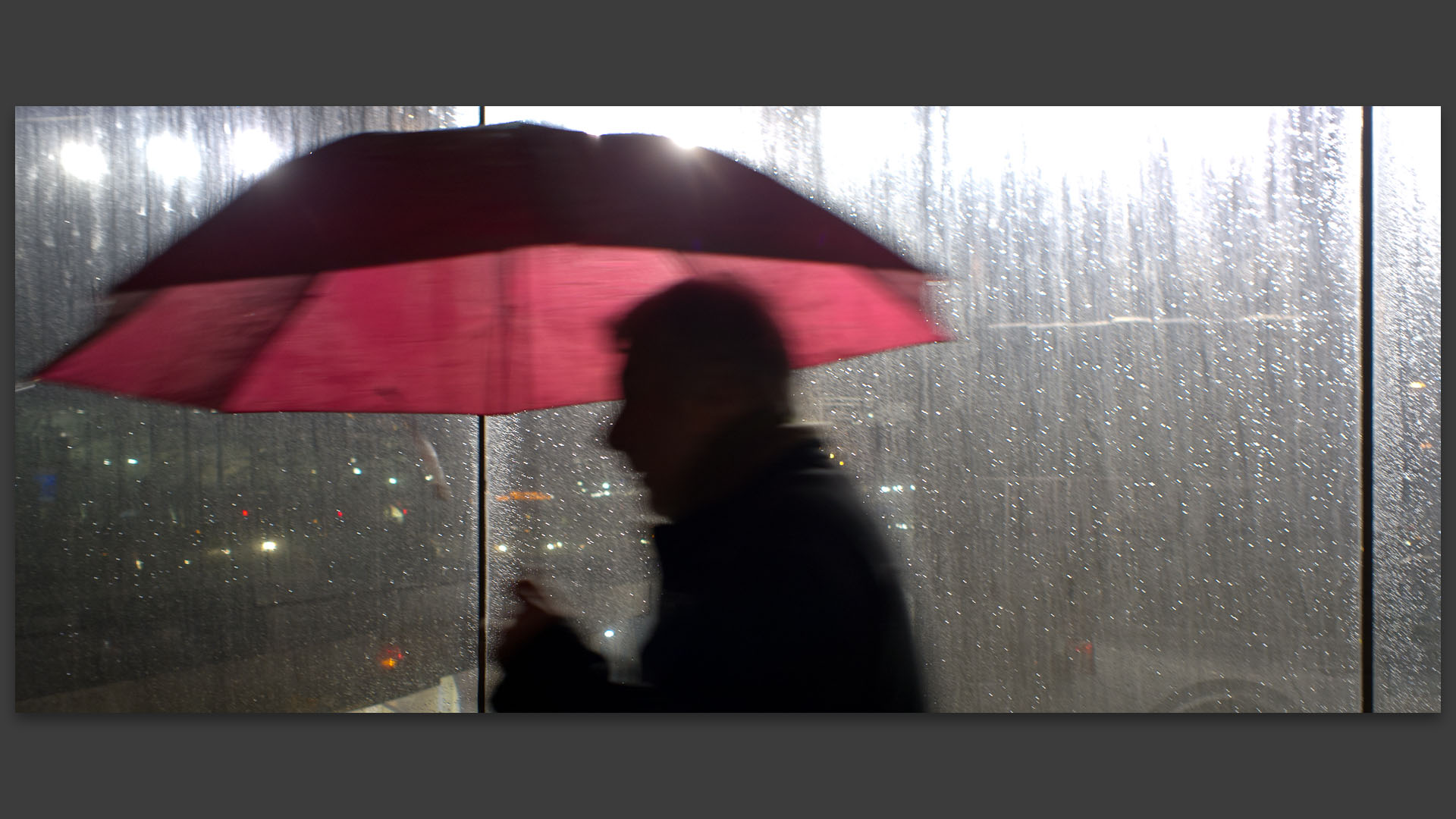 Homme avec un parapluie rouge, station de métro Lille Europe.