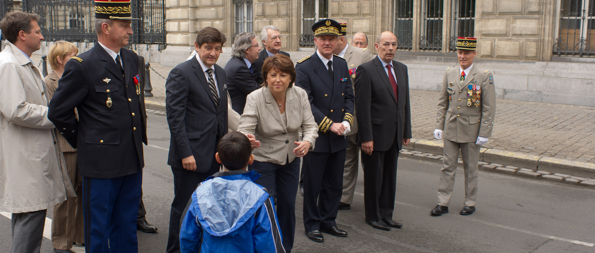 Martine Aubry tendant les bras à un enfant, pendant la cérémonie du 14 juillet, place de la République, à Lille.