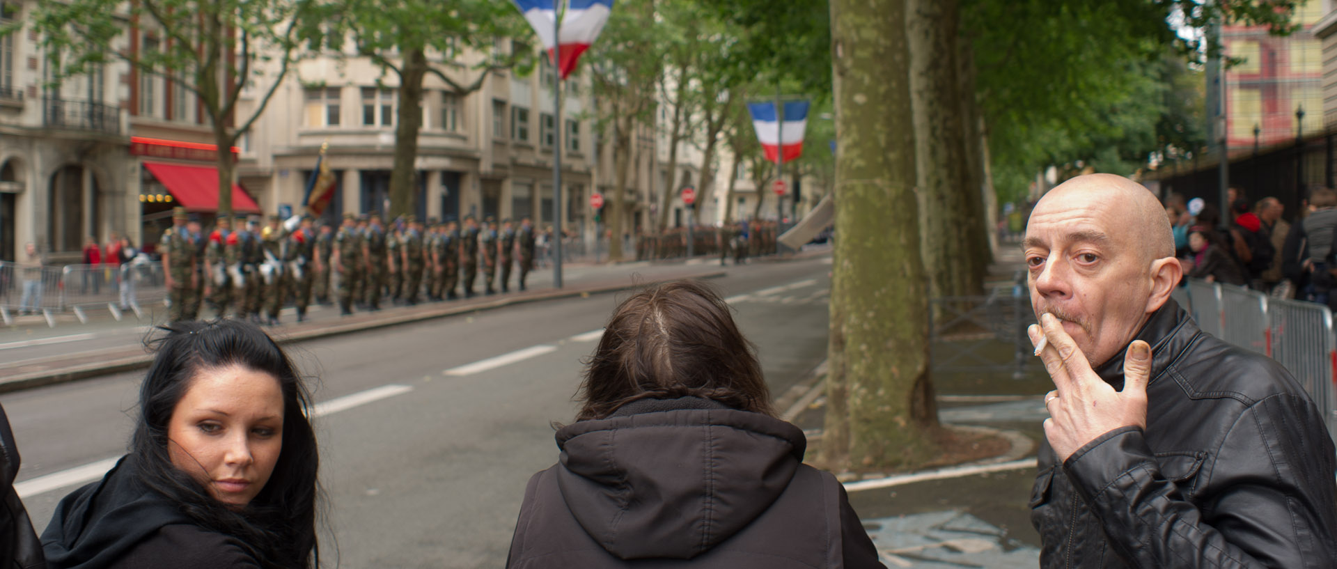 Petite cigarette en attendant le défilé motorisé du 14 juillet, boulevard de la Liberté, à Lille.