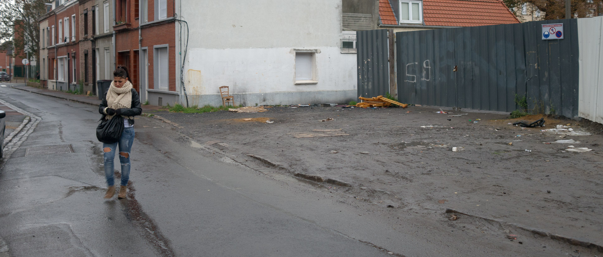 Jeune fille sous la pluie, rue Frémy, à Lille Fives.