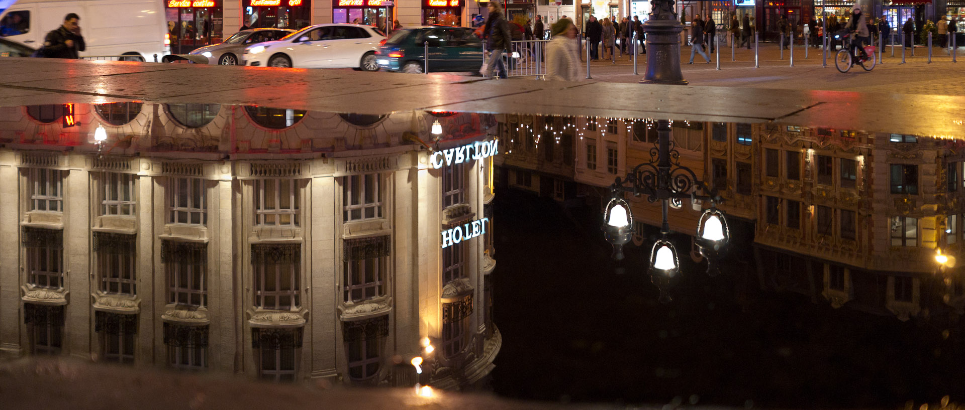 Reflet de l'hôtel Carlton dans un flaque, place du Théâtre, à Lille.