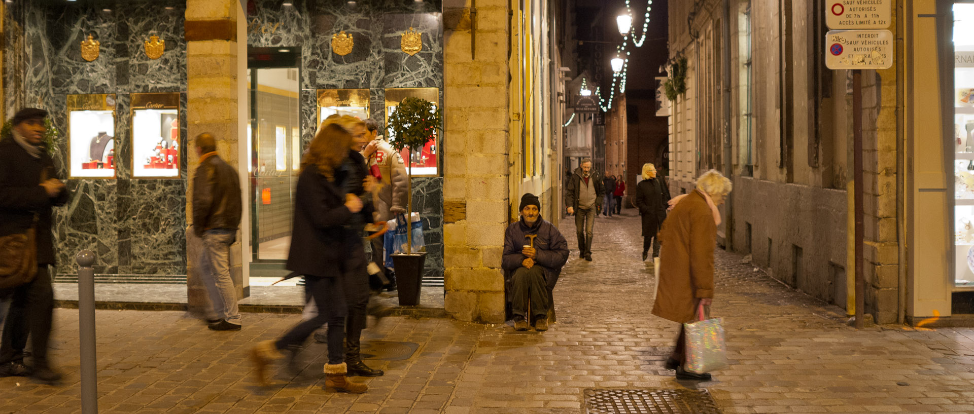 Passants et mendiant, rue Esquermoise, à Lille.