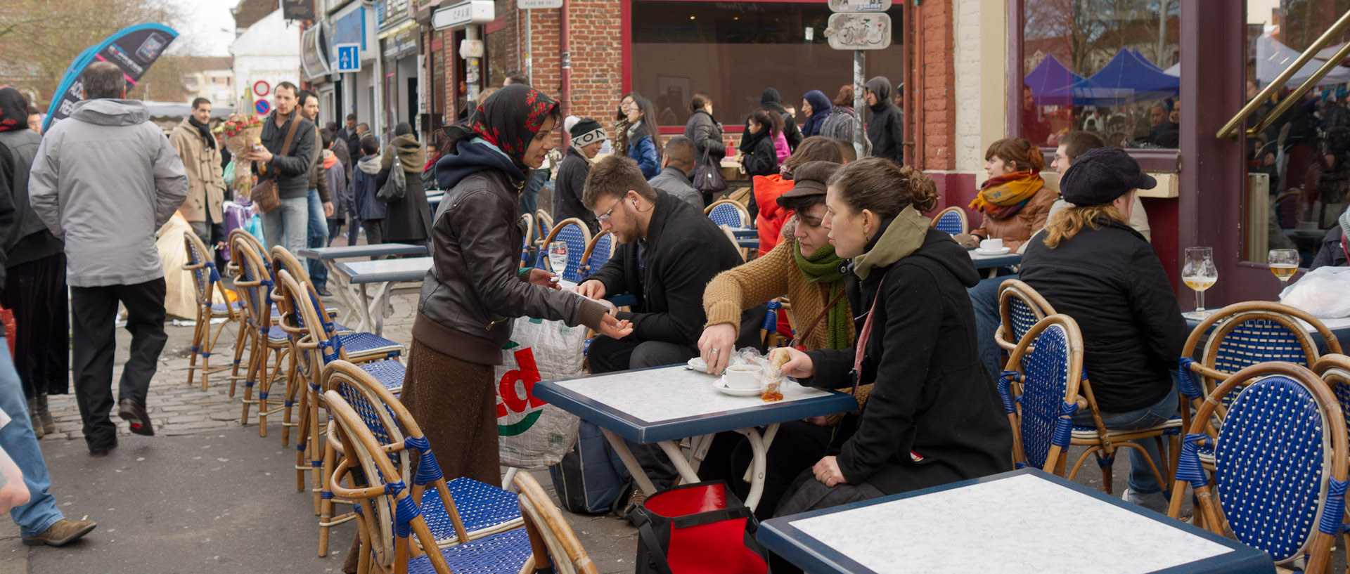 Mendiante à la terrasse d'un café, rue des Sarrazins, à Wazemmes, Lille.