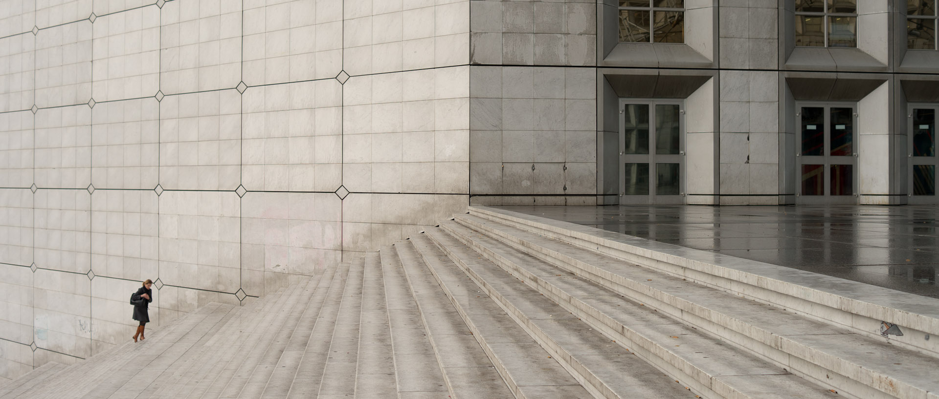 Femme gravissant les marches de la grande arche, à Paris La Défense.