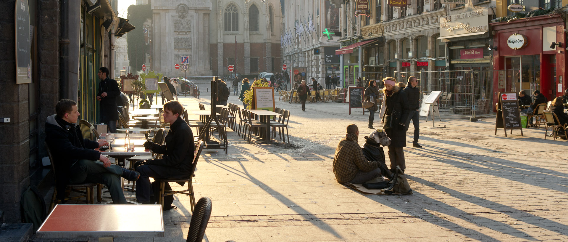 Clients en terrasse et mendiant, place Rihour, à Lille.