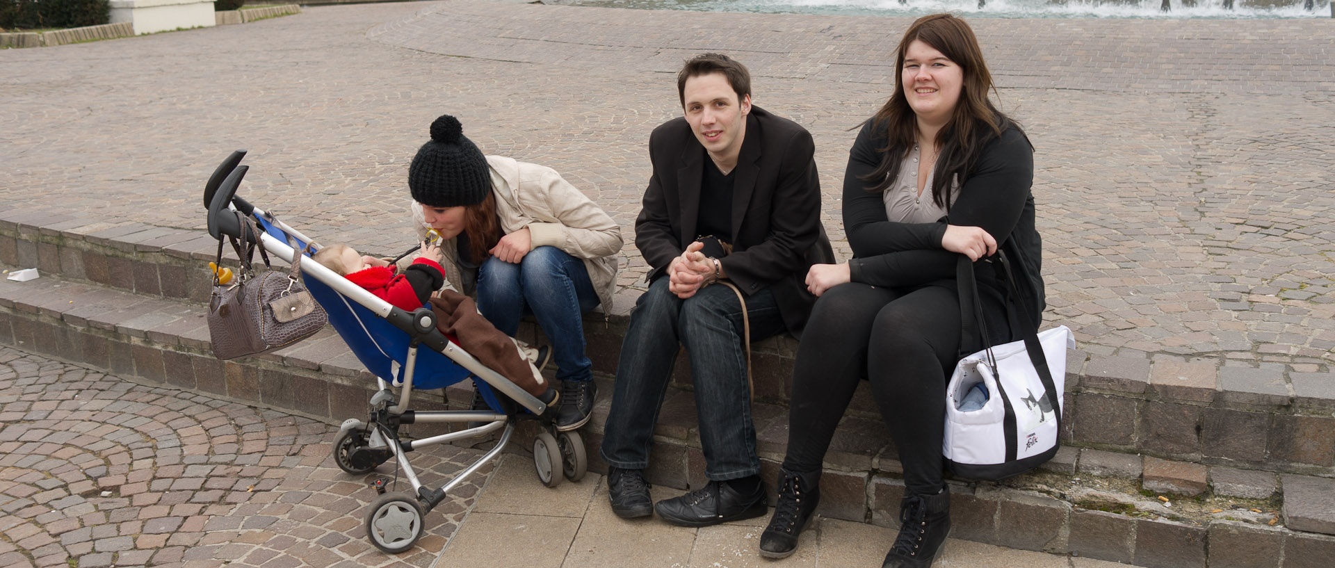 Jeunes adultes et un bébé assis place de la République, à Lille.