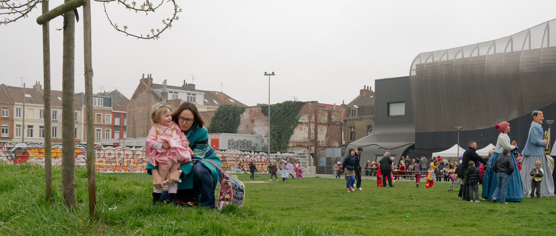 Mère reculottant sa petite fille ayant fait pipi, au carnaval de Wazemmes, à la Maison Folie Wazemmes, à Lille.