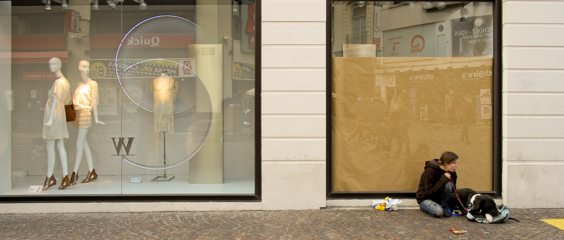 Mendiante avec son chien devant un magasin de vêtements, rue de Béthune, à Lille.