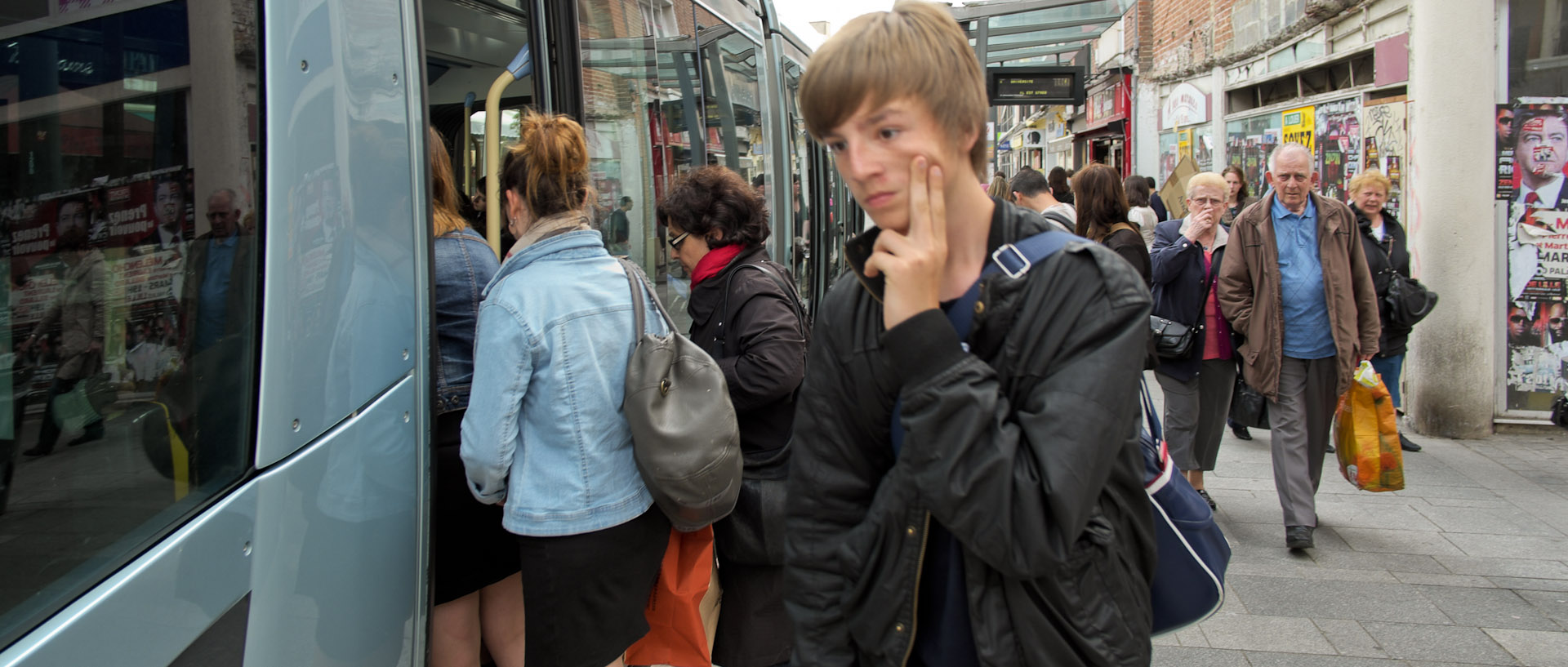 Jeune homme pensif à la descente d'un tramway, rue de la Vieille Poissonnerie, à Valenciennes.