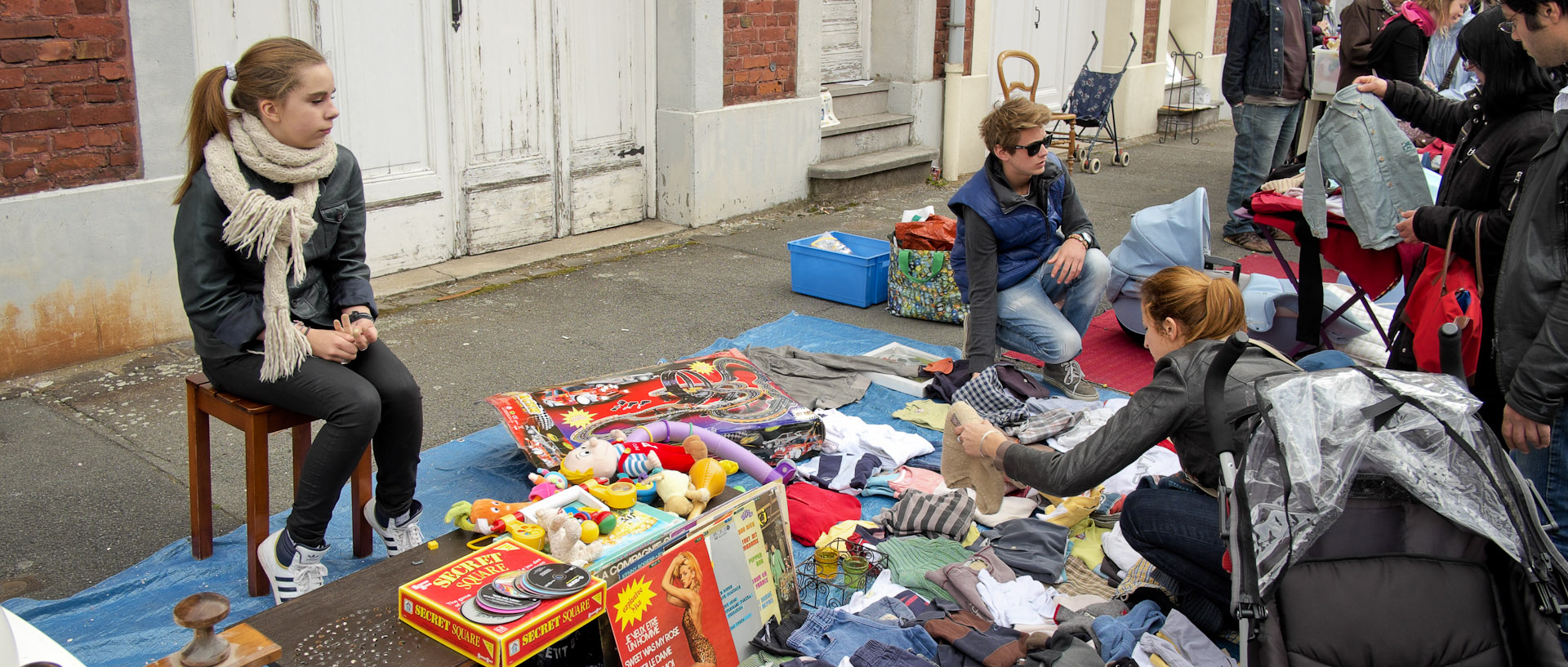 Jeune fille devant son étal pendant une braderie, rue Victor-Hugo, à Croix.