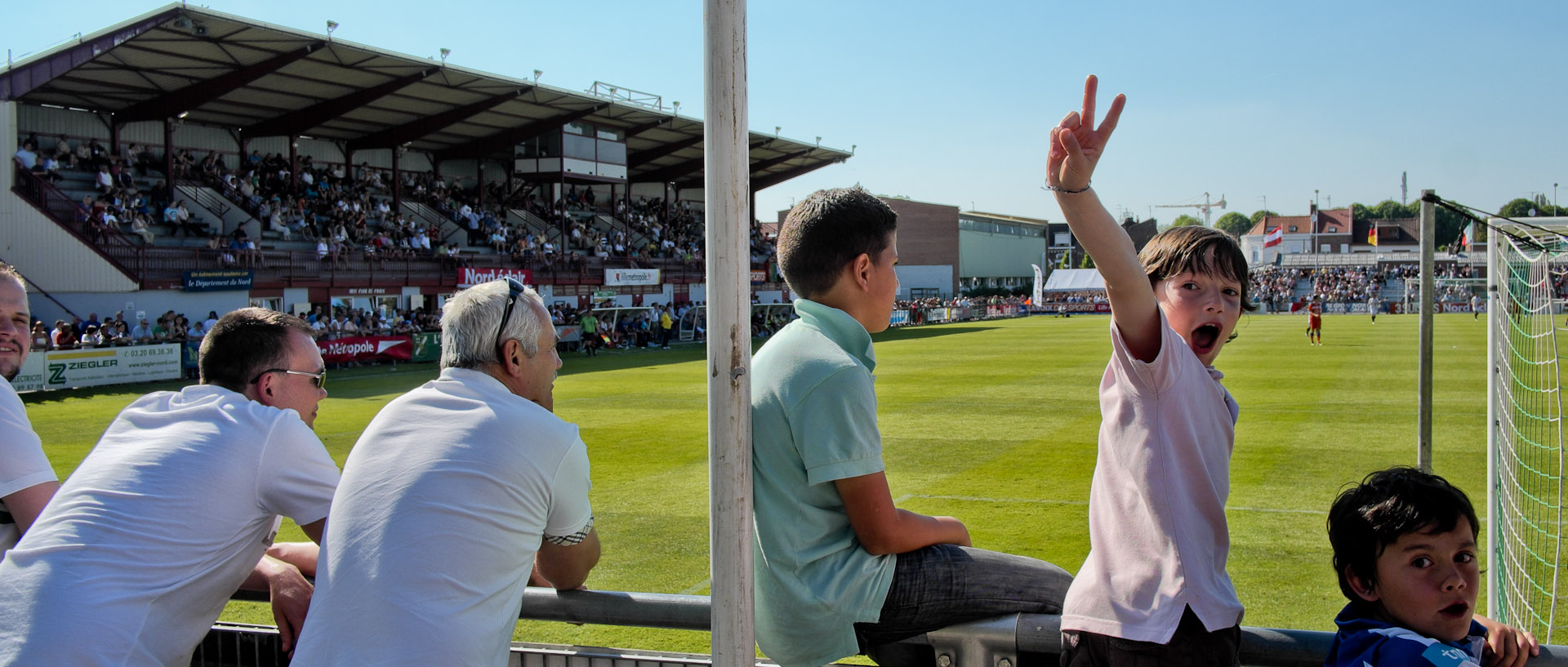 Garçon faisant le v de la victoire, pendant le tournoi international de football, au stade de Croix.