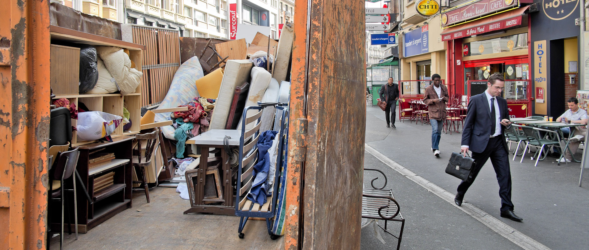 En costume cravate devant un bric à brac, rue du Molinel, à Lille.