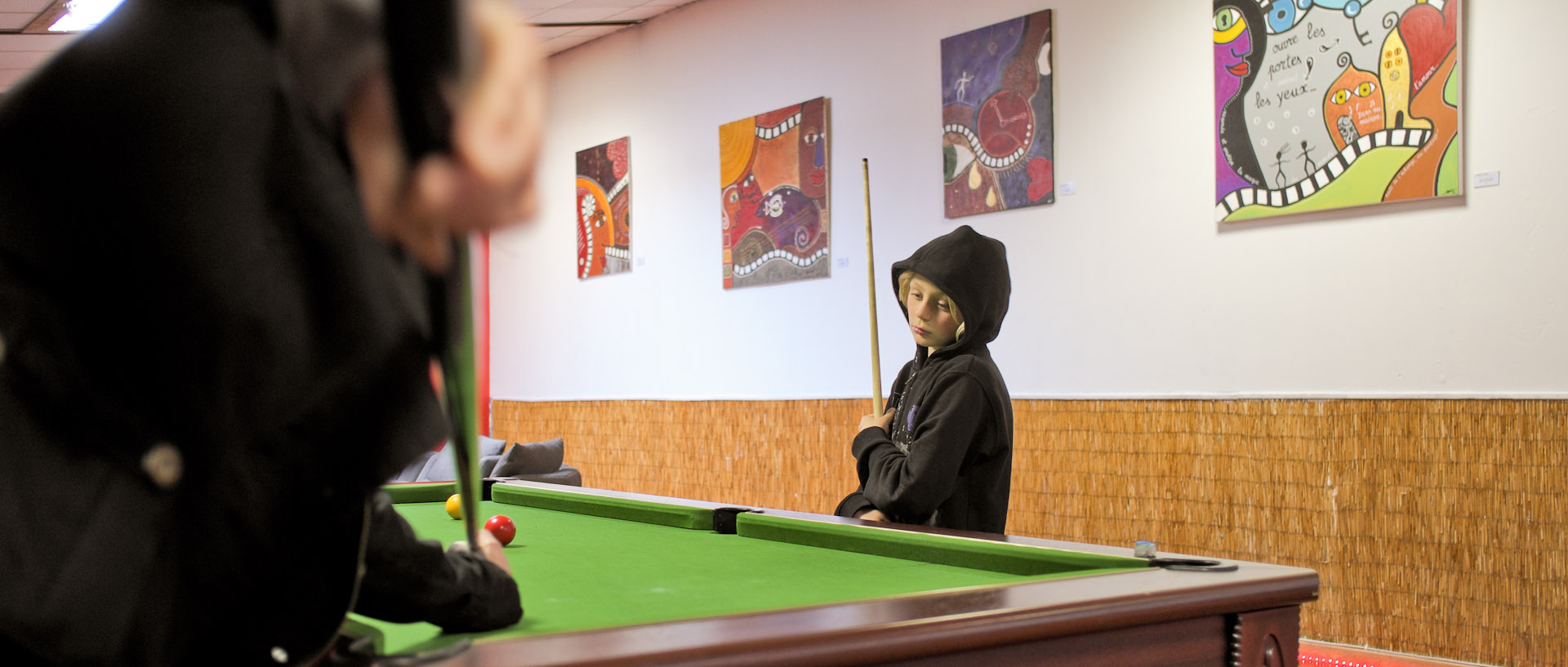 Enfant rêveur devant un billard, au Waz Factory, rue des Sarrazins, à Wazemmes, Lille.