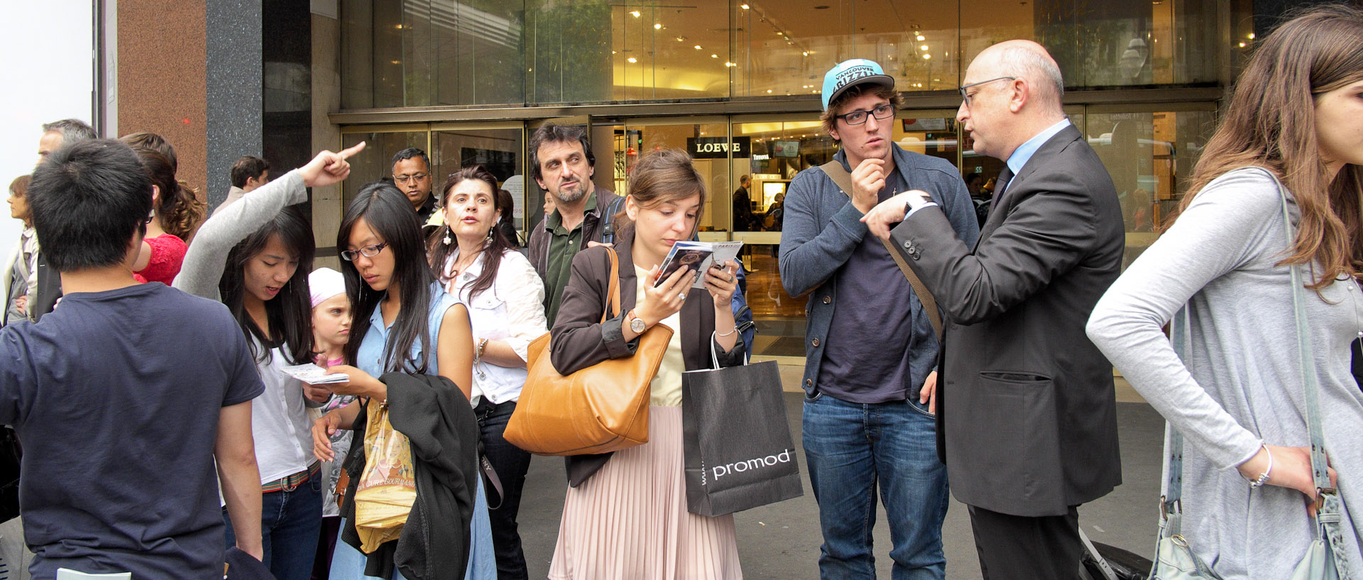 Touristes cherchant leur route, devant les Galeries Lafayette, boulevard Haussmann, à Paris.