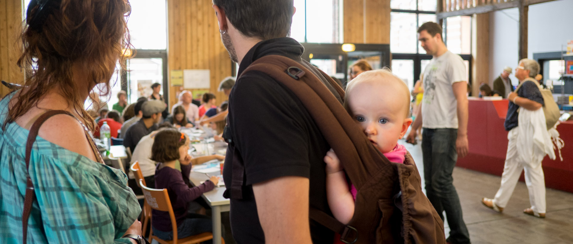 Bébé sur le dos de son père, pendant l'anniversaire de la radio associative RCV, à la Gare Saint Sauveur, à Lille.