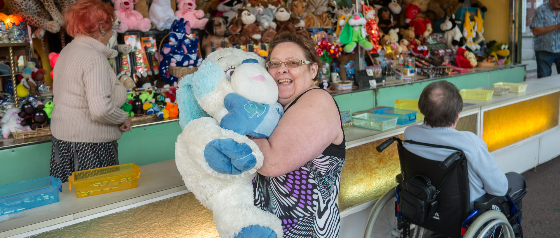 Femme ayant gagné une peluche dans une ducasse, place de la Liberté, à Croix.