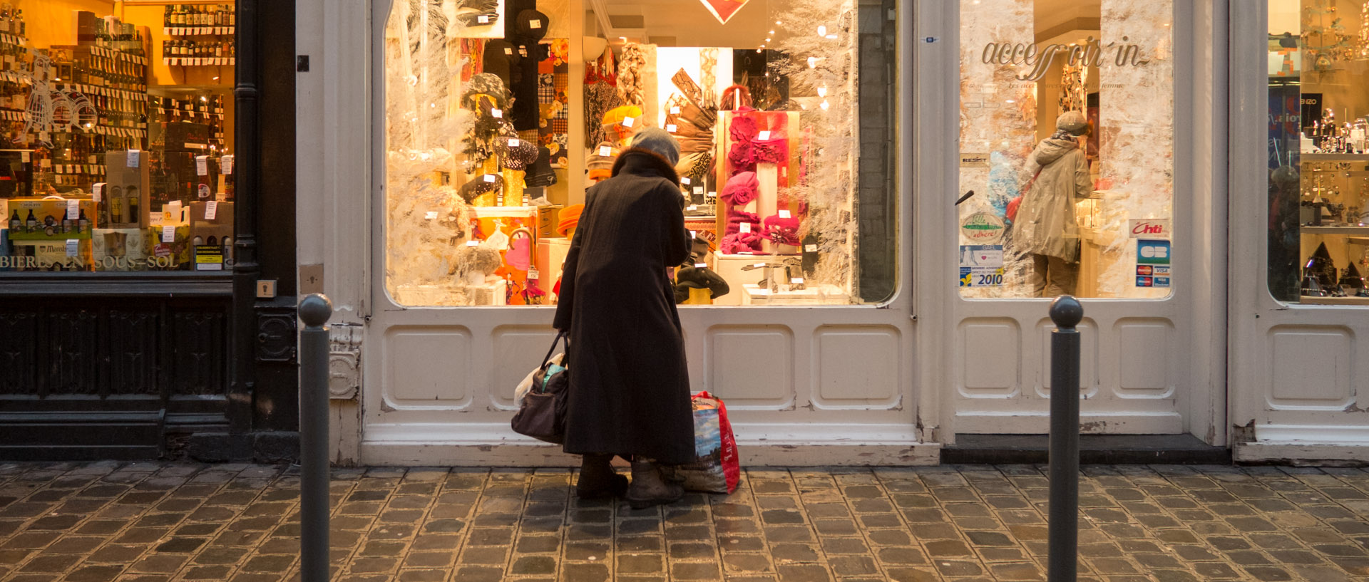 Vieille femme devant une vitrine, rue Esquermoise, à Lille.