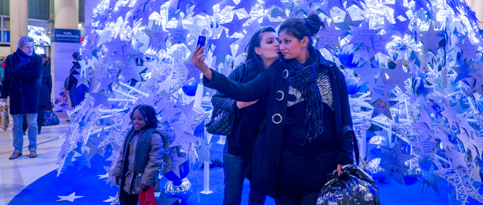 Femmes se photographiant devant des décorations de Noël, Forum des Halles, à Paris.