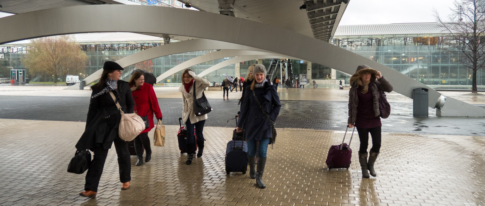 Passantes dans le vent et la pluie, devant la gare Lille Europe.