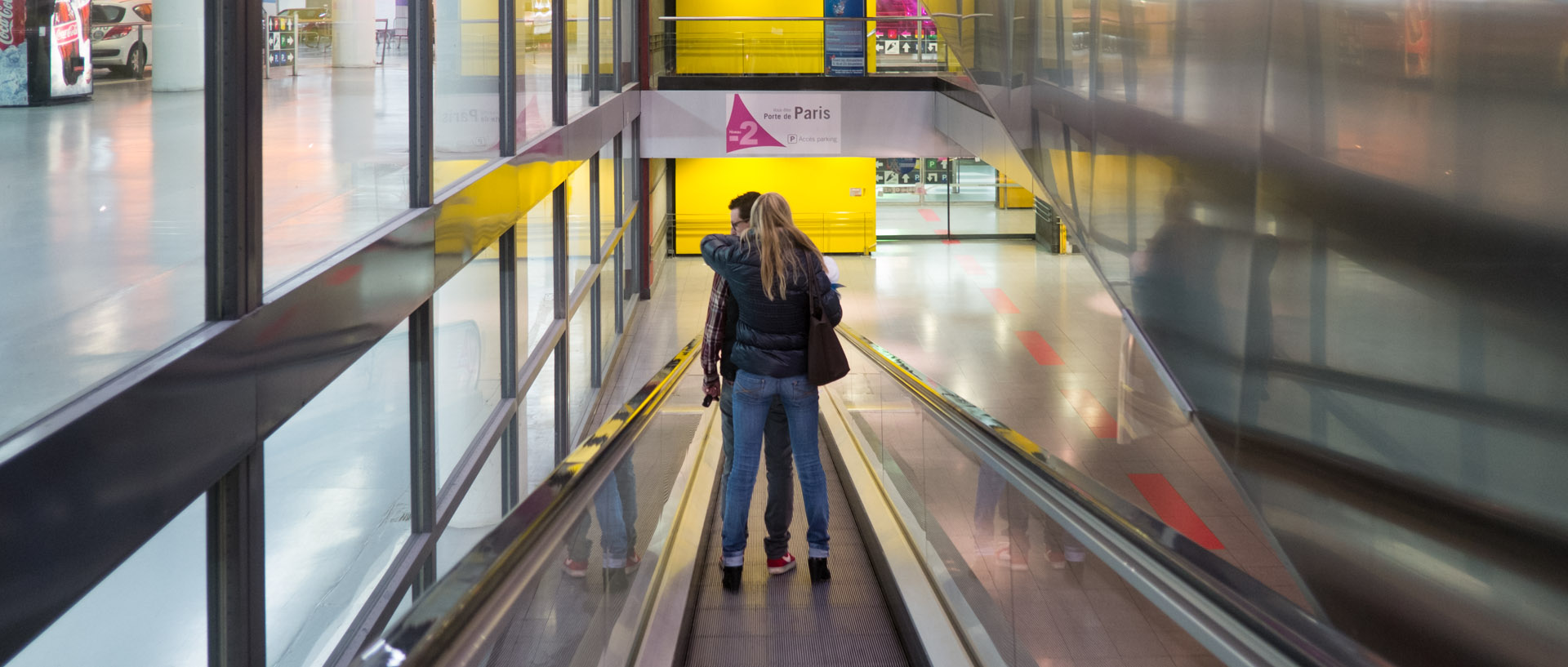 Couple sur un tapis roulant, dans le parking du centre commercial d'Euralille.