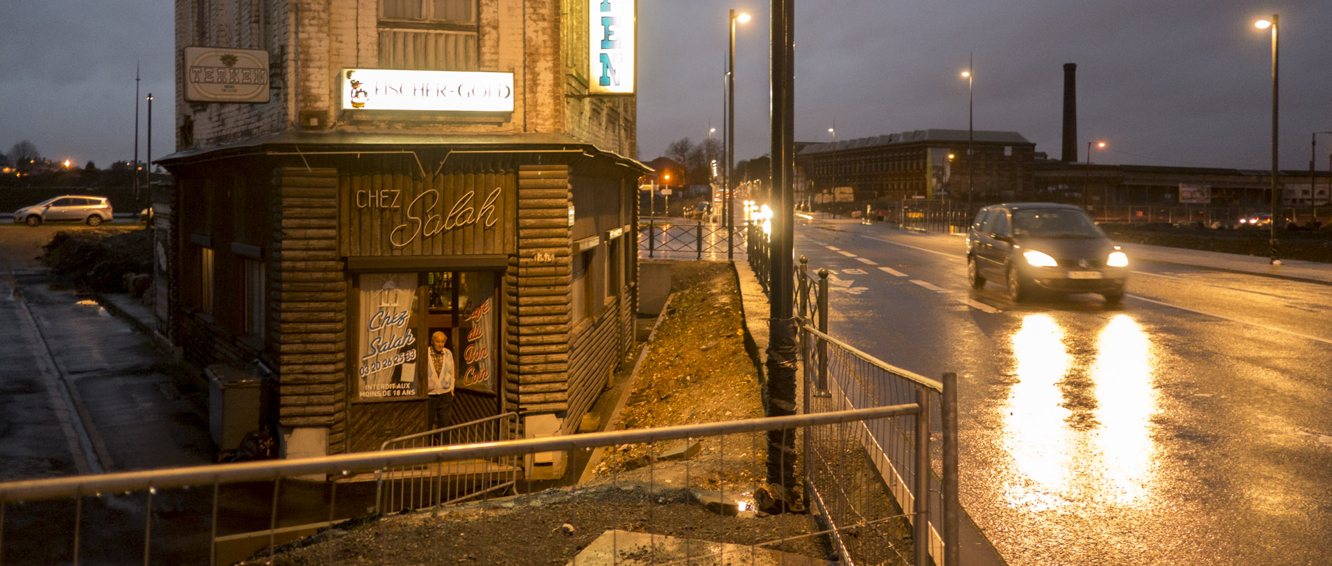 Salah sur le pas de porte de son café, dans la friche industrielle de la Zone de l'Union, à Roubaix.