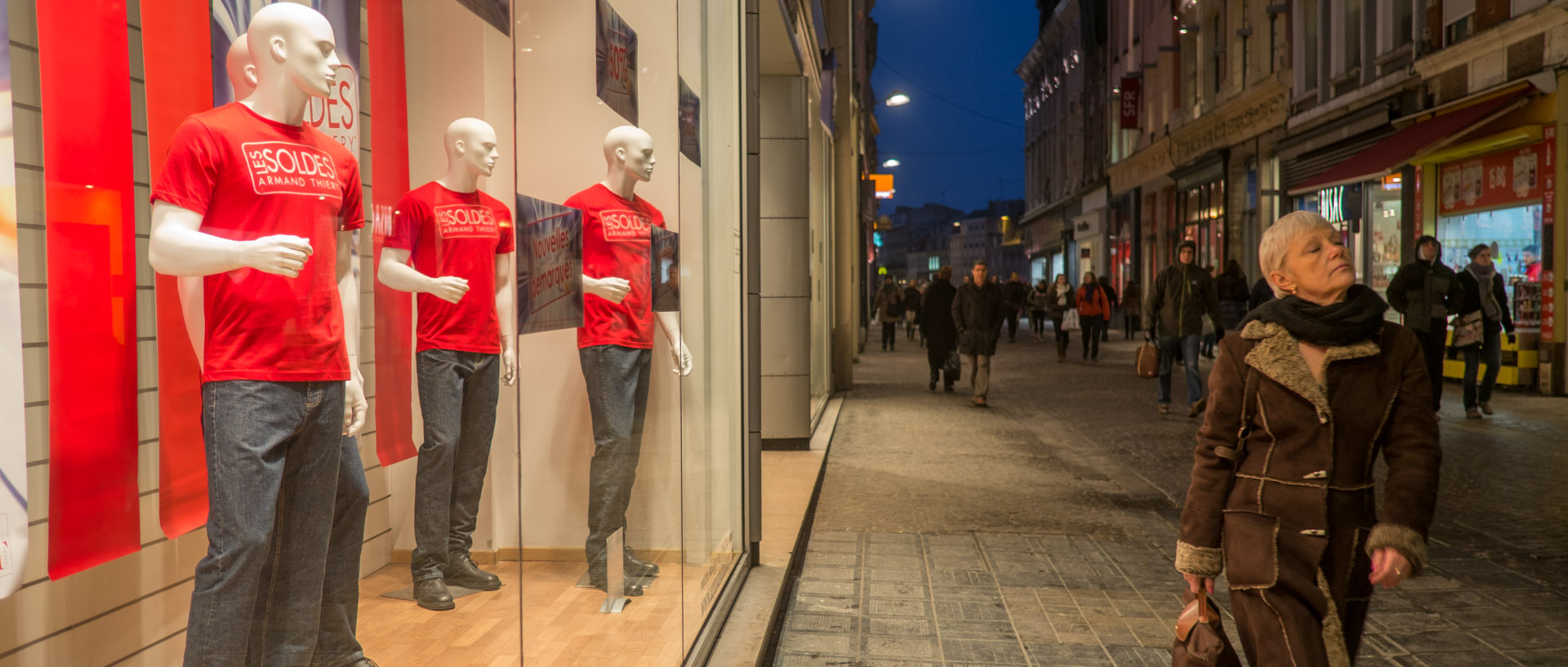 Femme passant devant une vitrine, rue Neuve, à Lille.