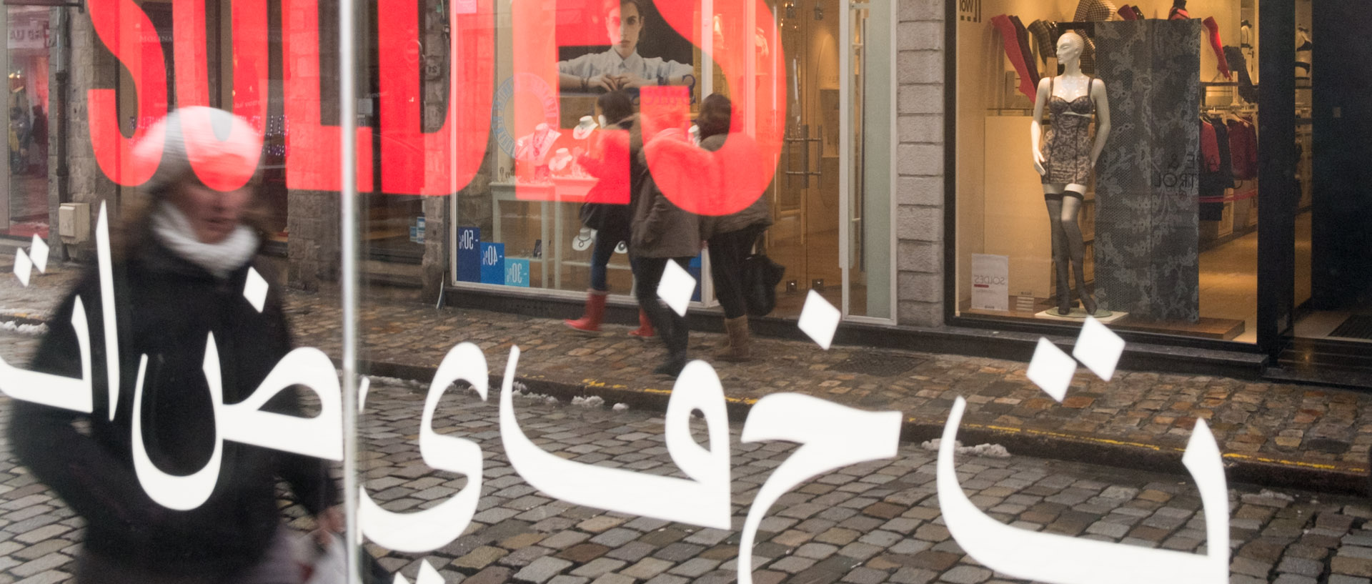 Vitrine de soldes écrite en Français et en Arabe, rue de la Grande Chaussée, dans le Vieux Lille.