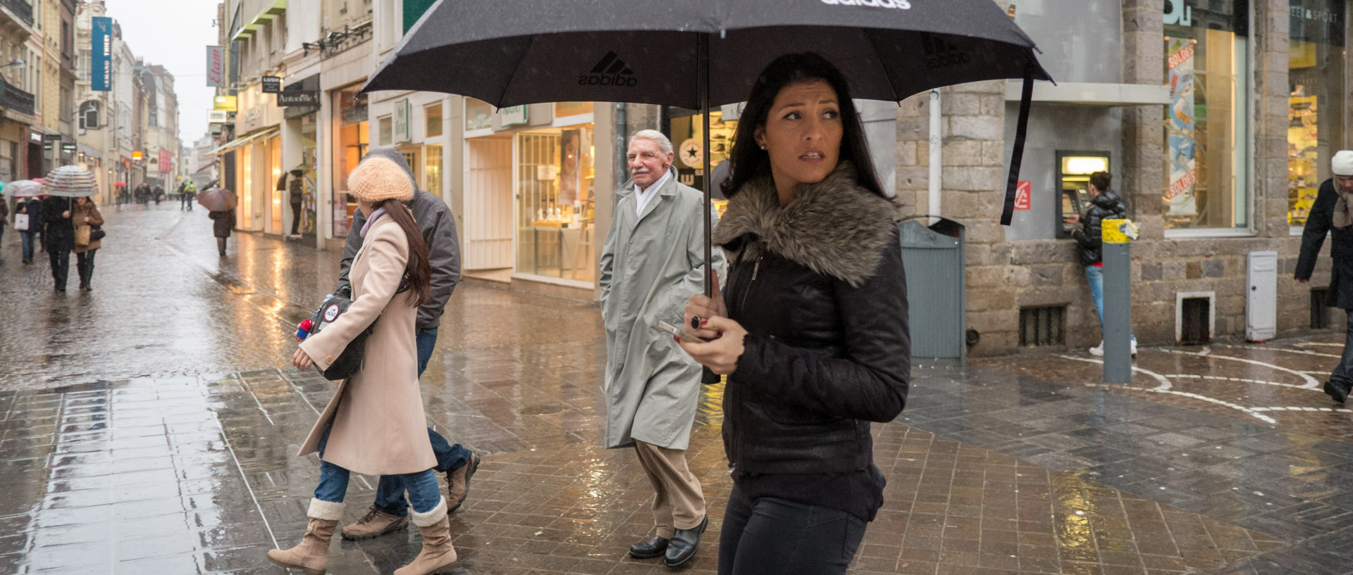 Jeune femme avec un parapluie, rue des Tanneurs, à Lille.