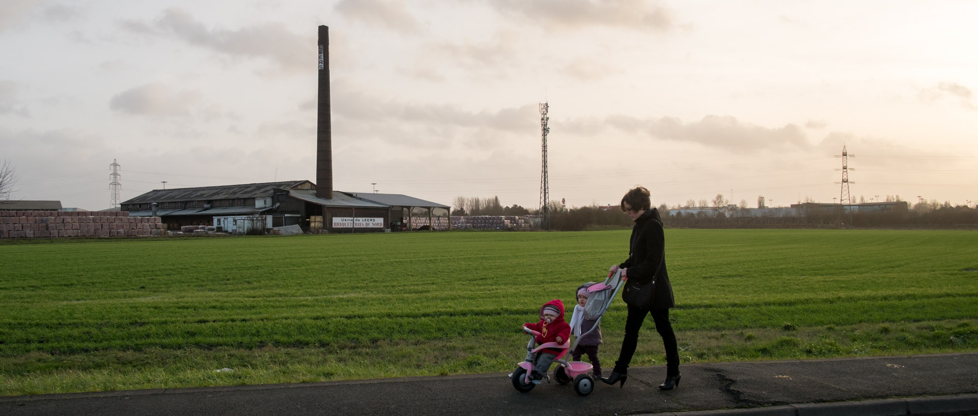 Femme et ses enfants devant les Briqueteries du Nord, à Leers.