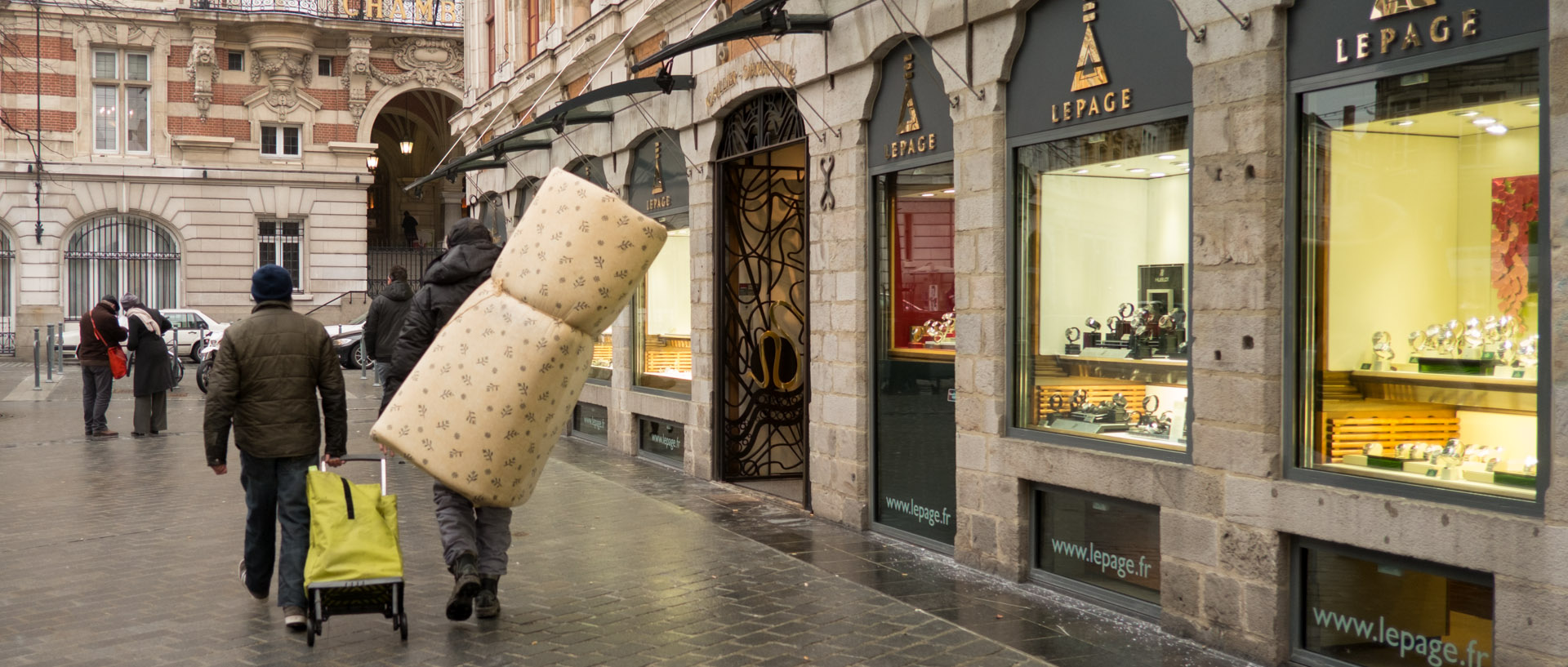 130213103524_Pont_chemin_ferHomme avec un matelas sur le dos, rue de la Bourse, à Lille.