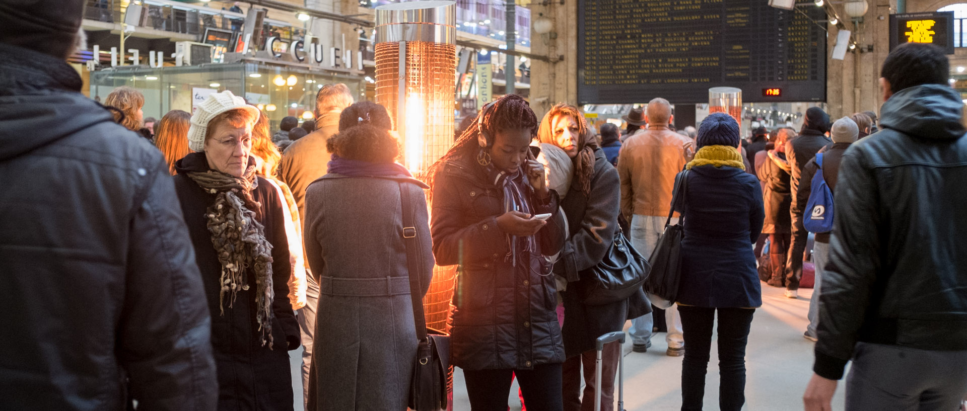 Voyageurs devant un brasero électrique, gare du Nord, a Paris.