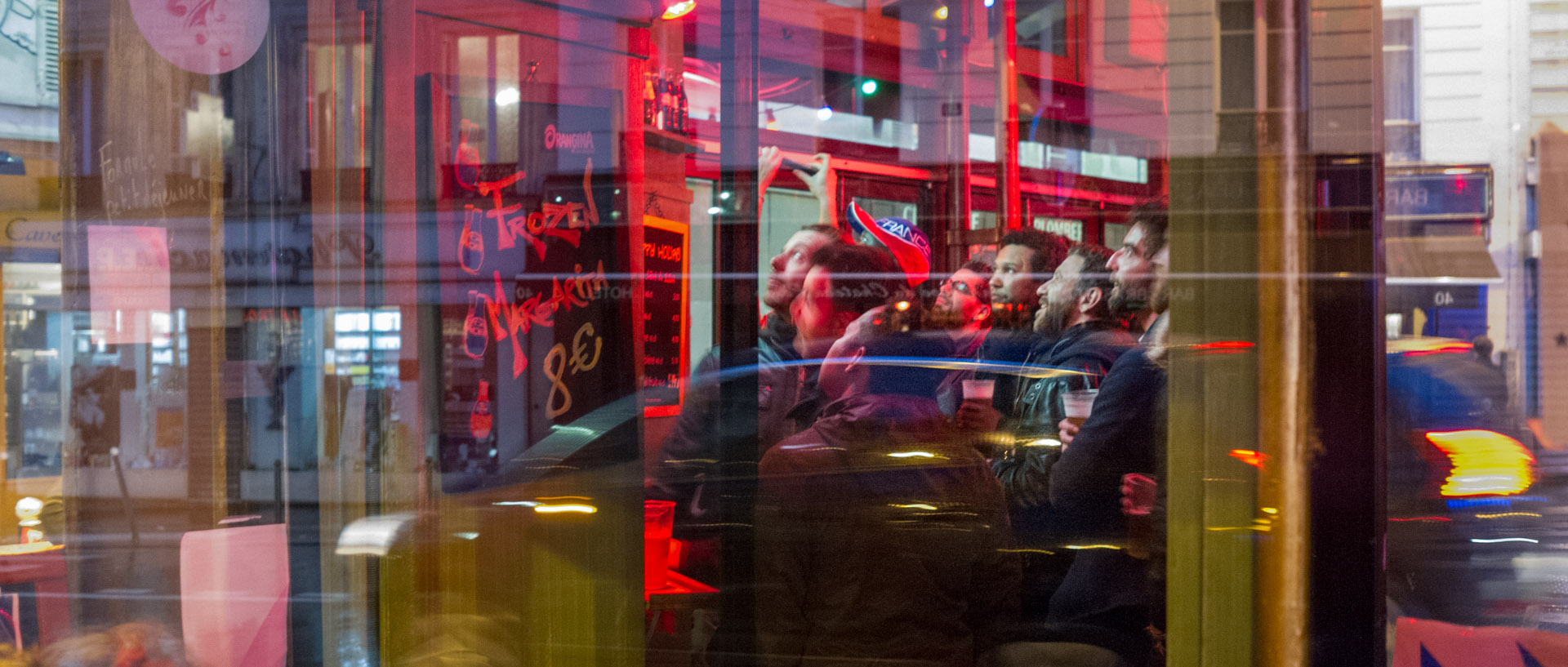 Clients suivant un match de foot à la télé, dans un café, rue Ramey, à Paris.