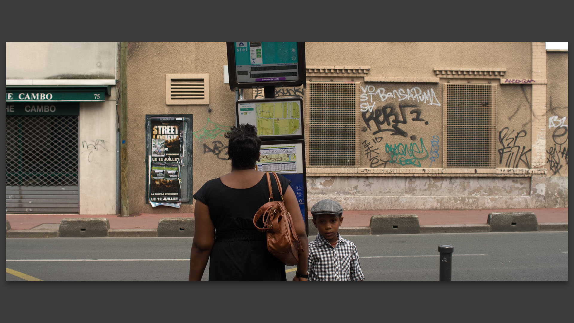 Une femme et son fils attendant l'autobus, rue des Rosiers, à Saint-Ouen.
